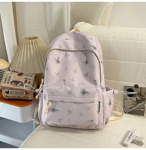 Détail du sac à dos en nylon lilas avec motifs de papillons gris et poche latérale