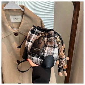 Detail van geruite bucket bag met trekkoord, lederen basis en schattige konijn