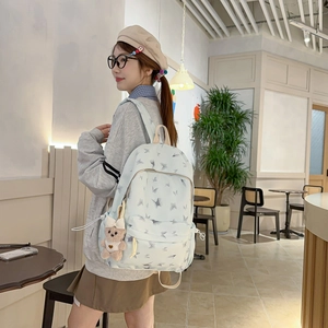 Détail du sac à dos scolaire vert menthe avec imprimé papillon et porte-clé ours