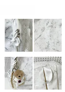 Detail view of marble print backpack features dual metal zippers and cute bear charm