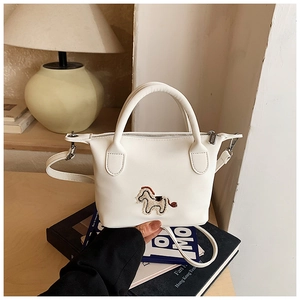 Détail du sac seau en cuir blanc avec broderie de cheval de dessin animé et fermeture