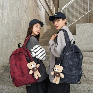 Detailed view of water-resistant canvas backpacks featuring star patterns and bear charms