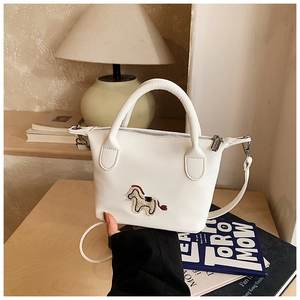 Gros plan du sac seau blanc crème avec broderie poney et fermeture à glissière