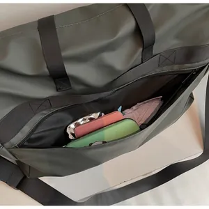 Detail of army green tote bag with zipper pocket showing large capacity for daily items