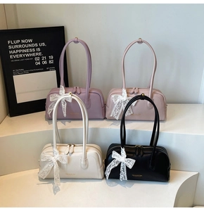 Détail des sacs Boston avec logo Maven & Chic et nœuds en dentelle en plusieurs couleurs