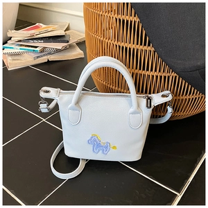 Détail du sac seau bleu avec broderie cheval et finitions en métal argenté poli
