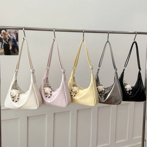 Vista detallada de cinco bolsos hobo fruncidos en cuero PU con colgantes de peluche