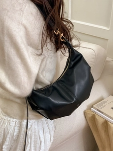 Minimalist black crescent crossbody bag with soft pleats and adjustable strap