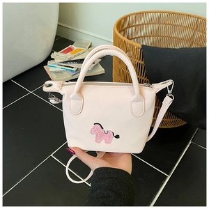 Détail du sac seau rose avec broderie poney et bandoulière en cuir amovible