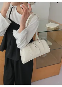 Close-up of cream white leather pillow bag with double strap detail and sleek matte finish