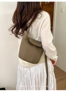 Close-up of retro brown pebbled leather bucket bag with white contrast stitching