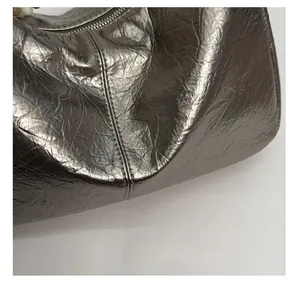 Macro shot of silver textured leather bag with metallic finish and zipper detail
