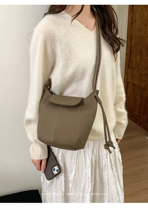 Close-up of retro leather bucket bag with drawstring details and fine stitching