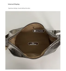 Top view of silver metallic shoulder bag interior showing main pocket and zipper pocket