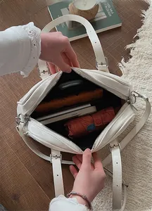 Macro view of white patent leather boston bag interior with large storage capacity