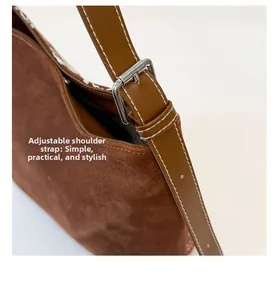 Détail de la bandoulière réglable et coutures blanches sur sac bandoulière marron
