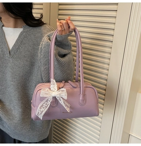 Détail du sac Boston en cuir lavande avec logo Maven & Chic et décoration de dentelle