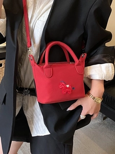 Mini sac cabas rouge avec broderie cheval et bandoulière amovible porté par modèle