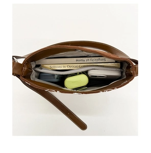 Vue intérieure montrant la grande capacité et les poches du sac seau en daim marron