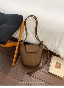 Detail of coffee brown bucket bag with lychee texture and slim dual shoulder straps
