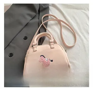 Gros plan détaillé du sac polochon rose avec broderie poney en peluche et texture de cuir