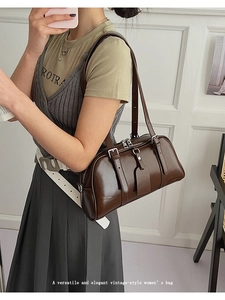 Detail of a brown vintage leather shoulder bag with silver hardware and double straps