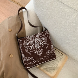 Détail du sac cabas bohème en daim marron avec broderie florale blanche et bandoulière