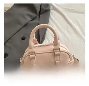 Détail du sac Boston rose clair en cuir PU texturé avec décoration de cœur en peluche