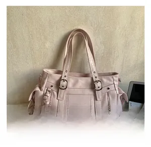 Detail of light pink multi-pocket tote bag showing buckles, zippers and matte PU texture