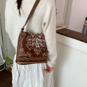 Vue arrière détaillée d'un sac à bandoulière en daim marron avec broderie bohème