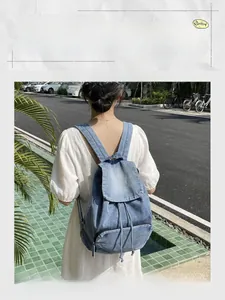 Detail view of vintage denim backpack showing adjustable straps and drawstring closure