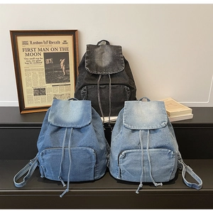 Sacs à dos en jean délavé vintage noir et bleu présentés dans un décor rétro chic