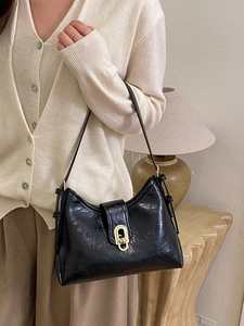 Vintage black underarm bag in glossy oil wax leather with elegant gold oval buckle