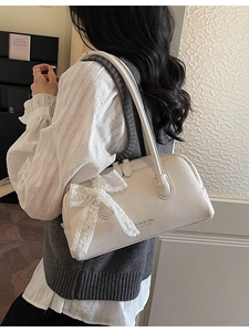 Sac Boston blanc élégant avec nœud en dentelle et texture cuir sur mannequin