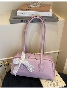 Sac Boston lavande chic avec nœud en dentelle et détails dorés sur une étagère