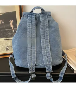 Vue détaillée des bretelles réglables en denim sur un sac à dos vintage bleu clair