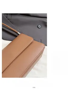 Gros plan sur un sac bandoulière marron caramel en cuir grainé avec surpiqûres