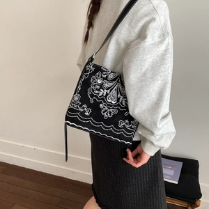 Vue détaillée des broderies blanches ethniques sur le sac à bandoulière vintage noir