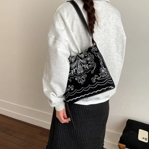 Détail du sac à bandoulière noir vintage avec une broderie blanche bohème très sophistiquée