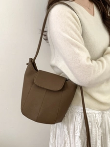 Brown litchi grain pumpkin bucket bag with vertical stitching shown on model