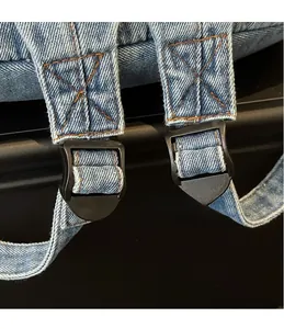 Détail de la bandoulière réglable du sac à dos en jean avec coutures orange renforcées