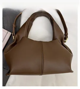 Close-up of coffee brown leather handbag showing its unique pleated folding structure