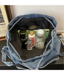 Intérieur spacieux du sac à dos en jean bleu avec rangement pour tablette et cosmétiques
