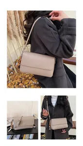Détail du sac bandoulière en cuir beige avec des pampilles décoratives en perles de bois