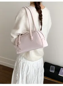Pink rectangular leather baguette bag featuring thin double straps and star charm