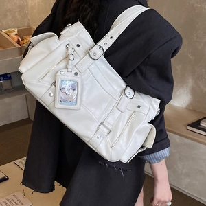 Dettaglio della borsa a tracolla bianco crema con tasche multiple e fibbie in argento