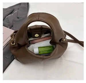 Detail view of brown cloud bag interior showing magnetic closure and storage space