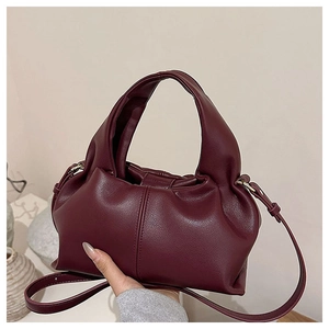 Close-up of burgundy ruched cloud bag showing premium leather texture and top handle