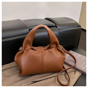 Detail of soft brown leather handbag with pleated design and detachable shoulder strap