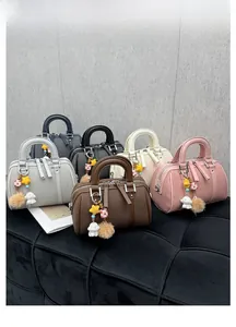 Détail de mini sacs Boston en cinq couleurs avec texture grainée et pendentifs mignons